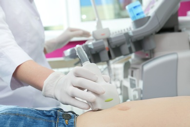 Photo of Doctor conducting ultrasound examination of internal organs in clinic, closeup