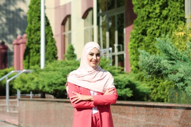 Photo of Muslim woman in hijab outdoors on sunny day