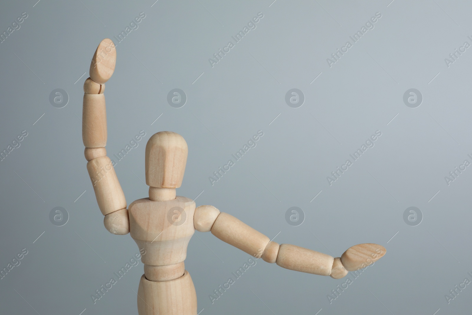 Photo of Wooden human model on grey background, space for text. Mini mannequin