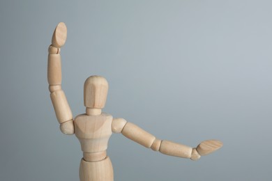 Wooden human model on grey background, space for text. Mini mannequin