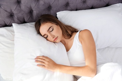 Photo of Beautiful teen girl sleeping with comfortable pillow in bed at home