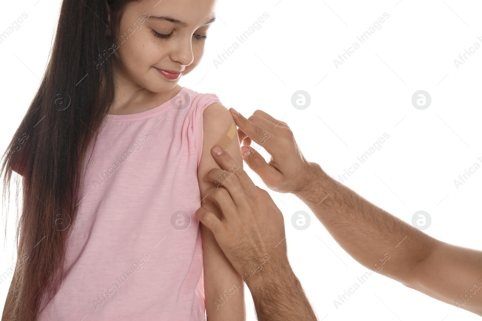 Photo of Man putting sticking plaster onto girl's arm on white background