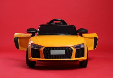 Child's electric toy car on red background