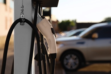 Photo of Electric vehicle charging station outdoors, closeup. Space for text