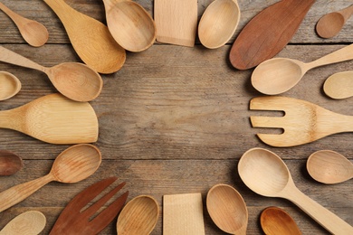 Photo of Frame of cooking utensils on wooden table, flat lay. Space for text
