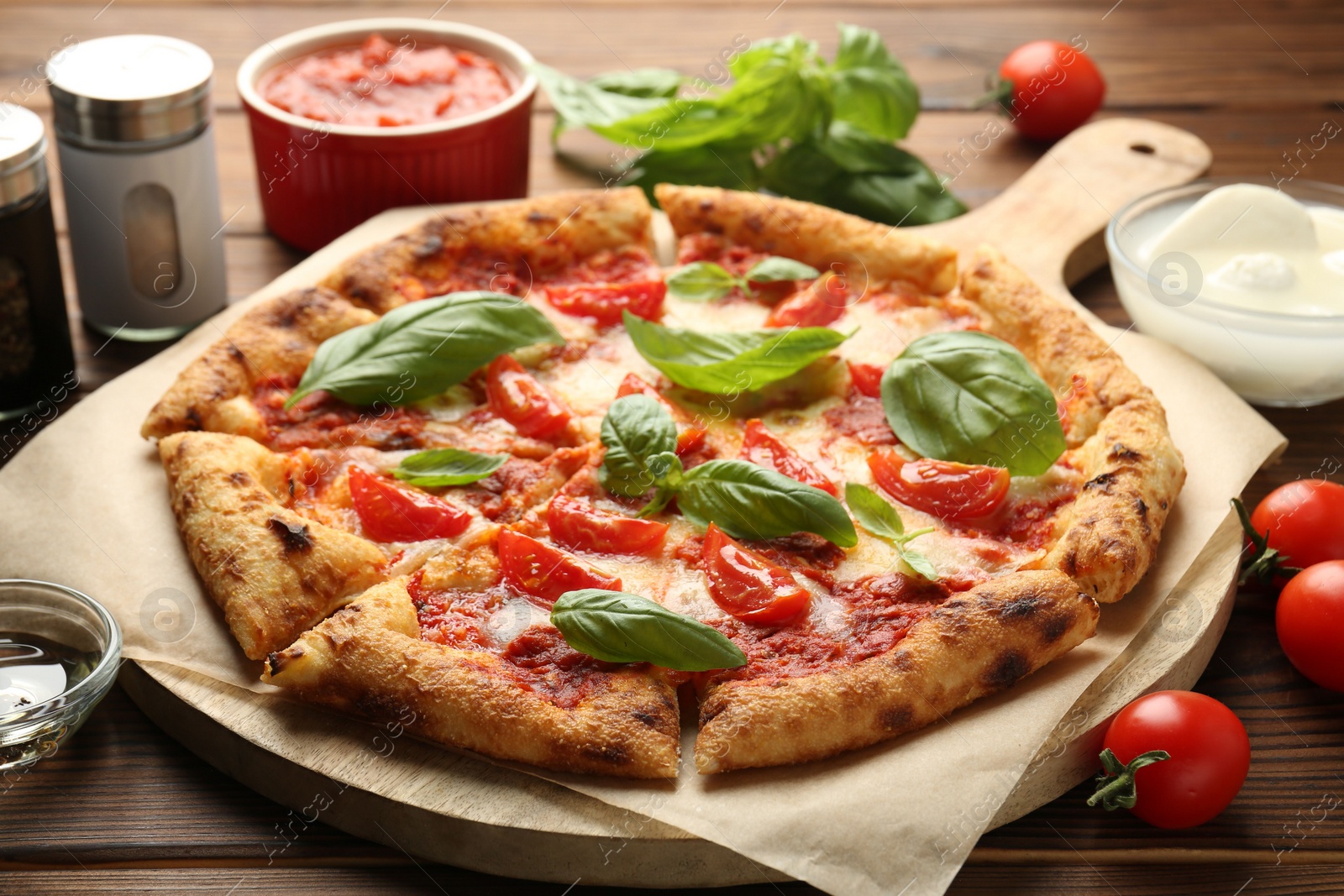 Photo of Delicious Margherita pizza and ingredients on wooden table