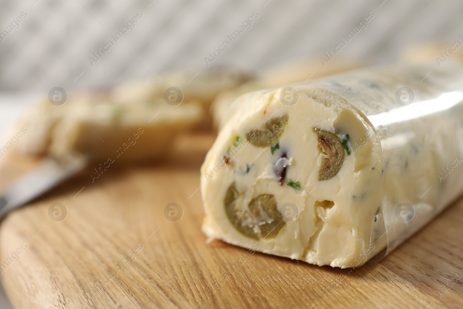 Photo of Tasty butter with olives and green onion on wooden board, closeup. Space for text