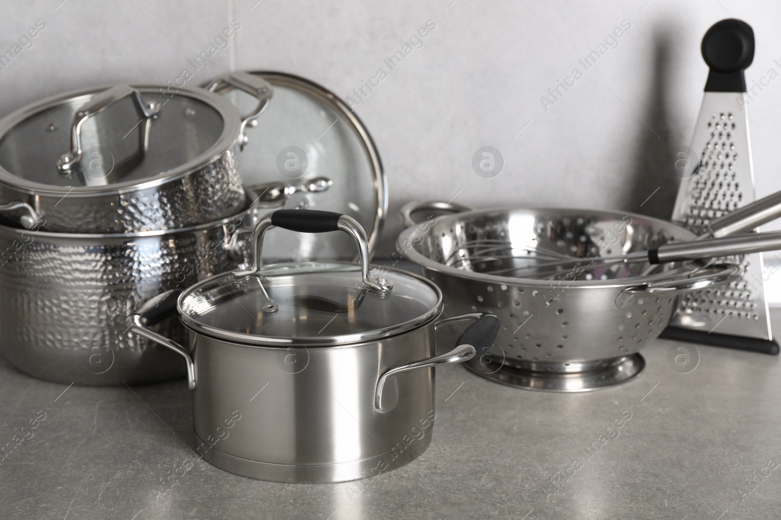 Photo of Set of different cooking utensils on grey countertop in kitchen