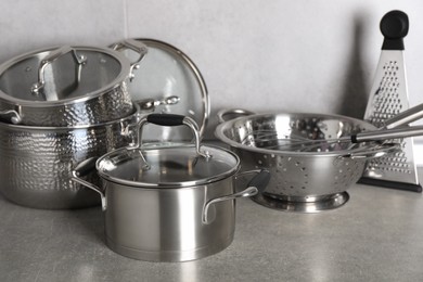 Set of different cooking utensils on grey countertop in kitchen