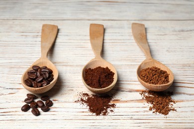 Photo of Instant, ground coffee and roasted beans on white wooden table