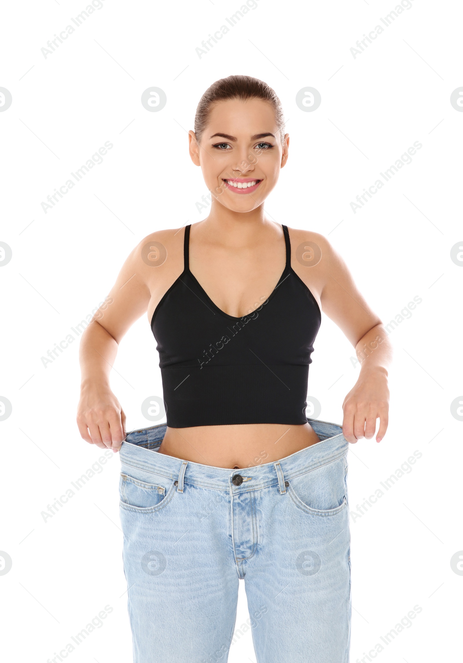 Photo of Slim woman in oversized jeans on white background. Weight loss