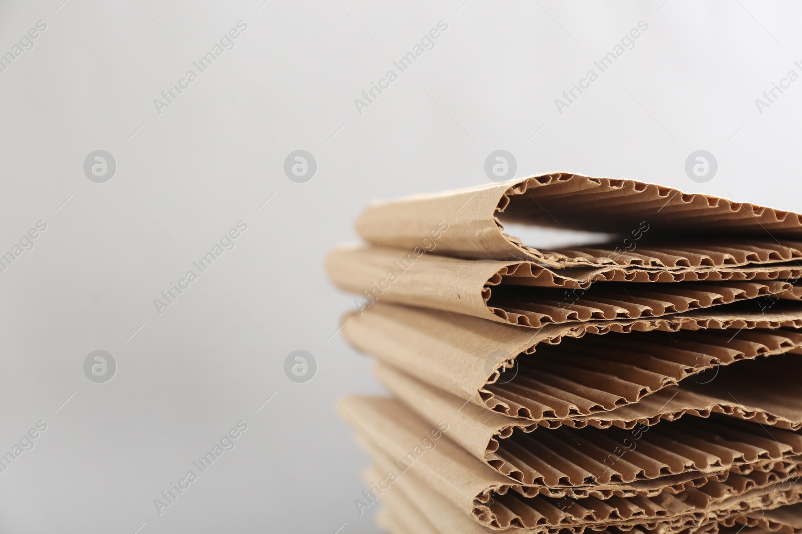 Photo of Stack of cardboard on light background, closeup with space for text. Recycling concept