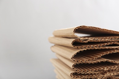 Photo of Stack of cardboard on light background, closeup with space for text. Recycling concept