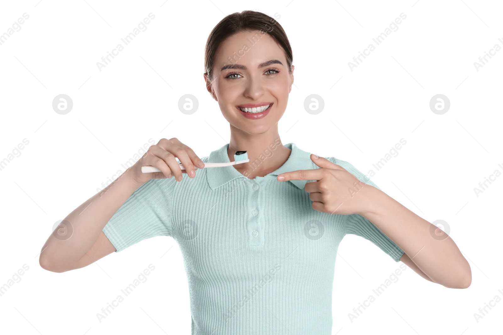 Photo of Young woman holding brush with charcoal toothpaste on white background