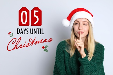 Image of Christmas countdown. Woman in Santa hat showing silence gesture on light grey background near text