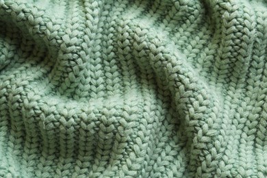 Photo of Beautiful pale green knitted fabric as background, top view