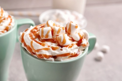 Photo of Cup with delicious caramel frappe on table, closeup