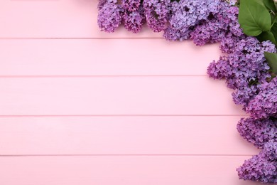 Photo of Beautiful lilac flowers on pink wooden background, top view with space for text