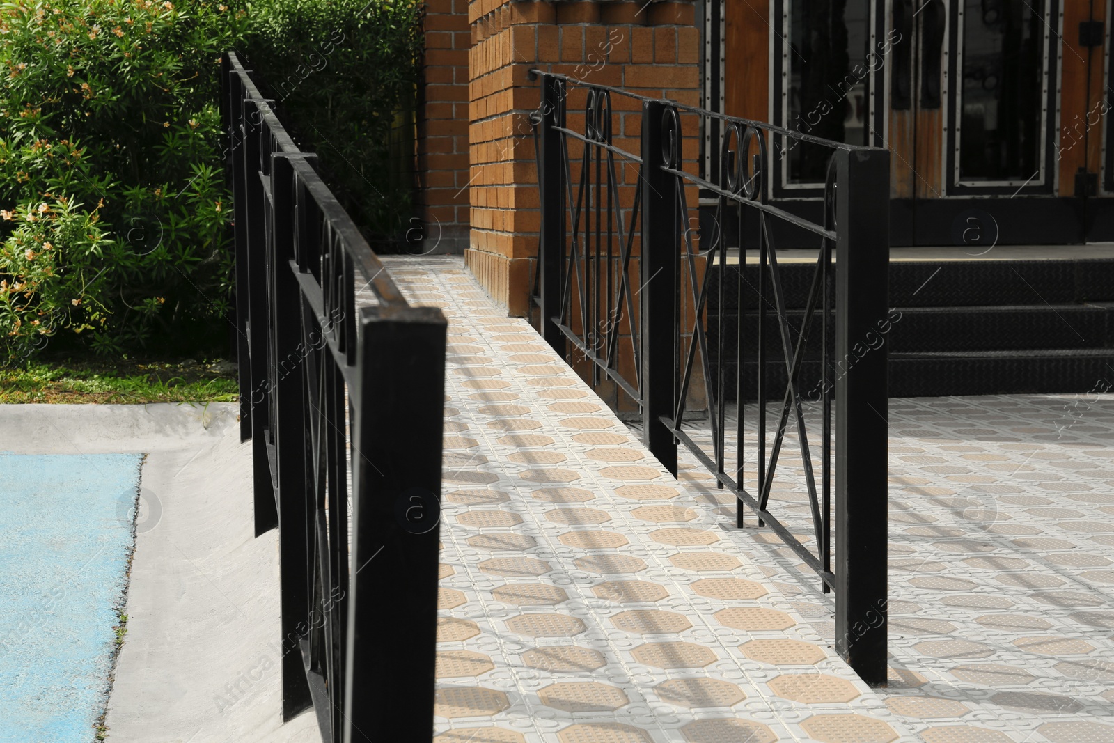 Photo of Tiled ramp with black metal railings outdoors