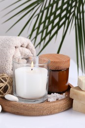 Photo of Composition with spa supplies on white table and palm leaf