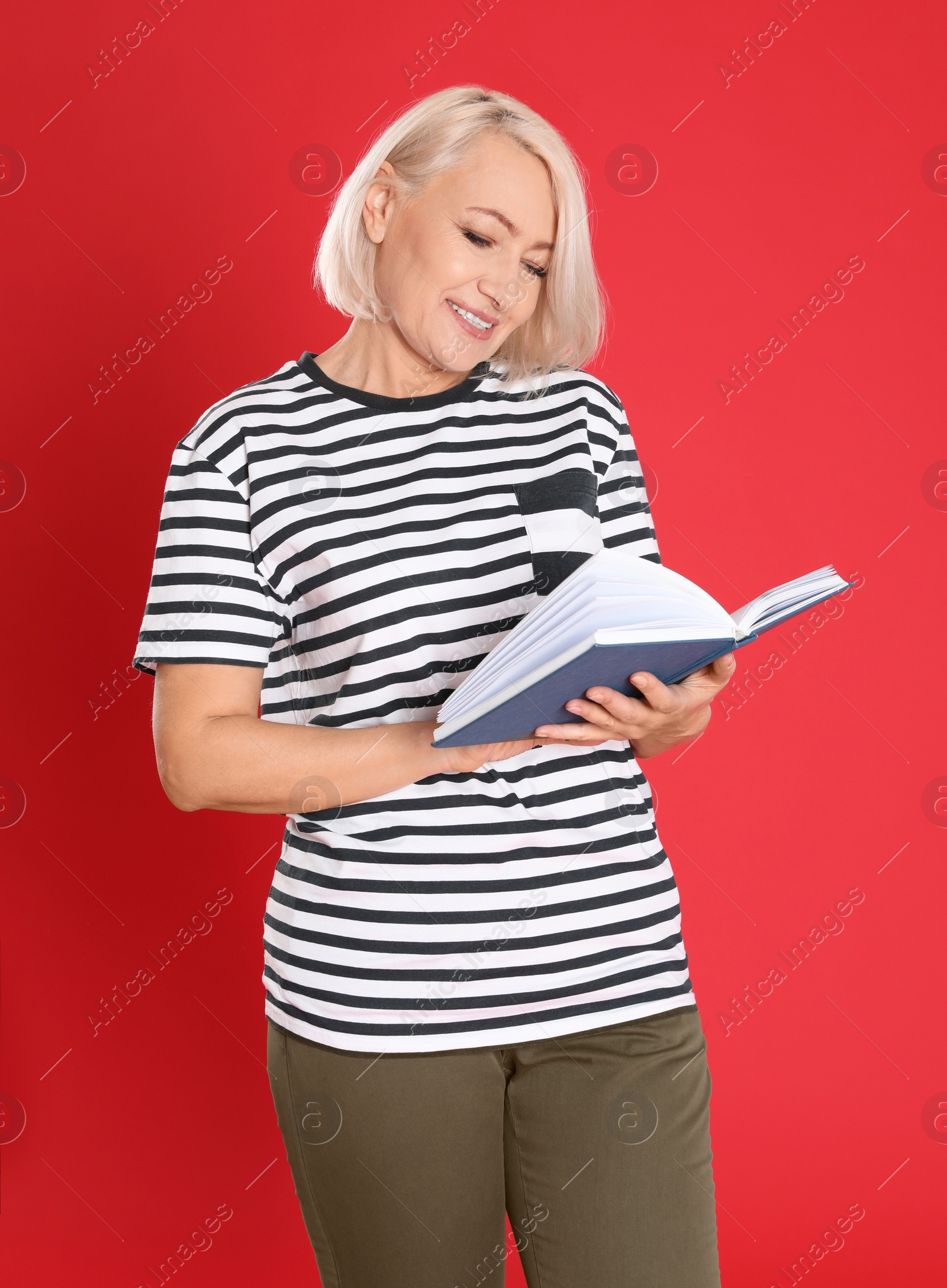 Photo of Senior woman reading book on color background
