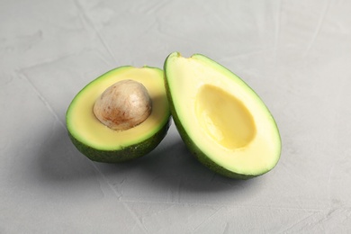 Tasty ripe green avocado on grey background