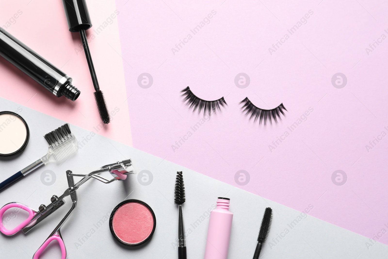 Photo of Flat lay composition with false eyelashes and other makeup products on color background, space for text