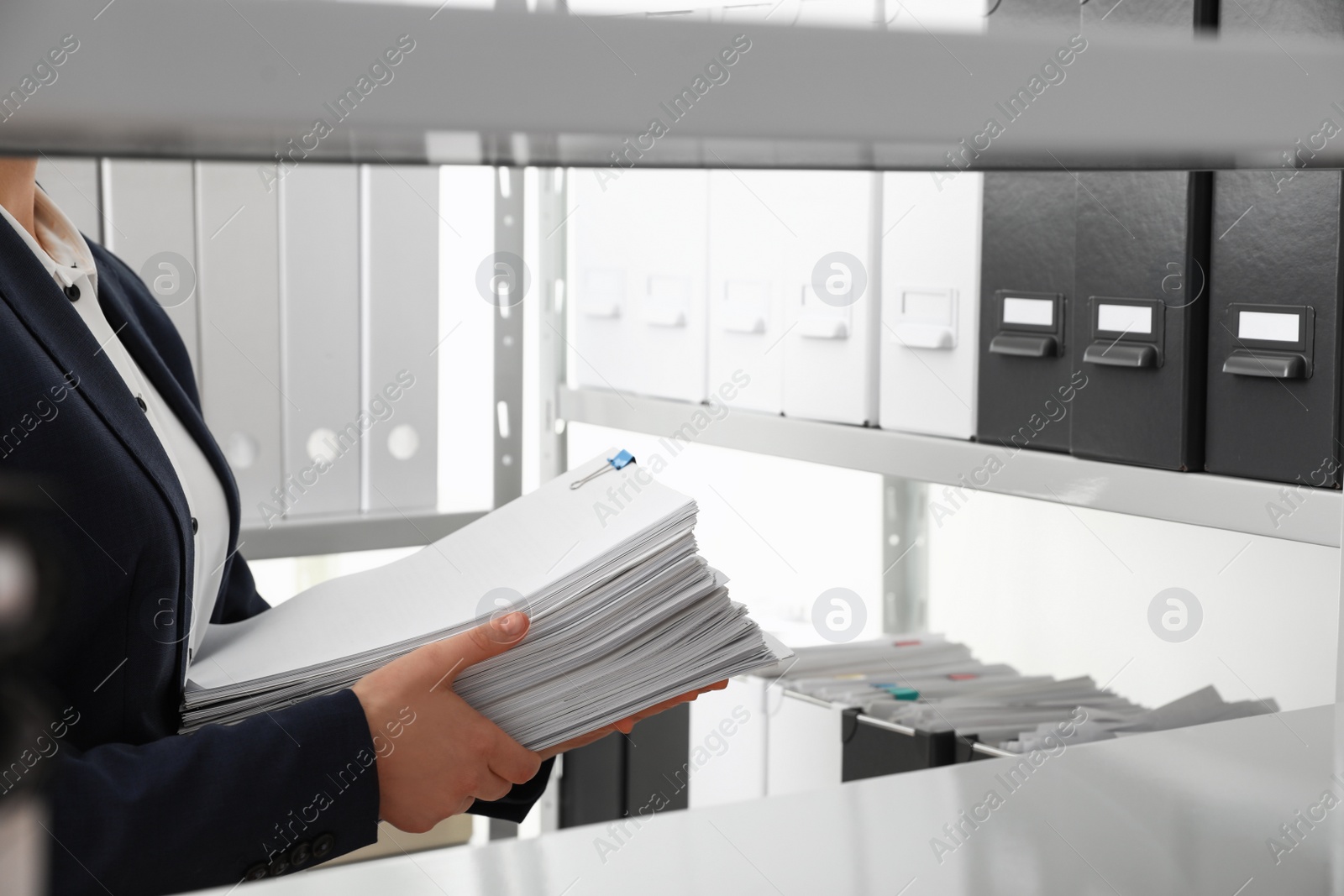 Photo of Female worker with documents in office, closeup. Space for text