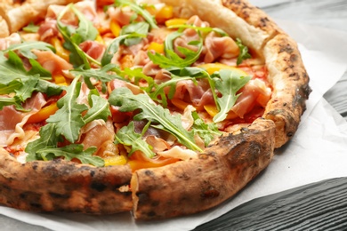 Tasty pizza with meat and arugula on grey wooden table, closeup