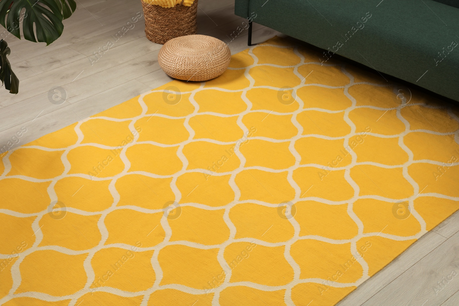 Photo of Yellow carpet with geometric pattern on wooden floor in room