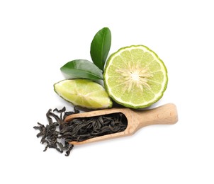 Photo of Dry bergamot tea leaves, wooden scoop and fresh fruit on white background, top view