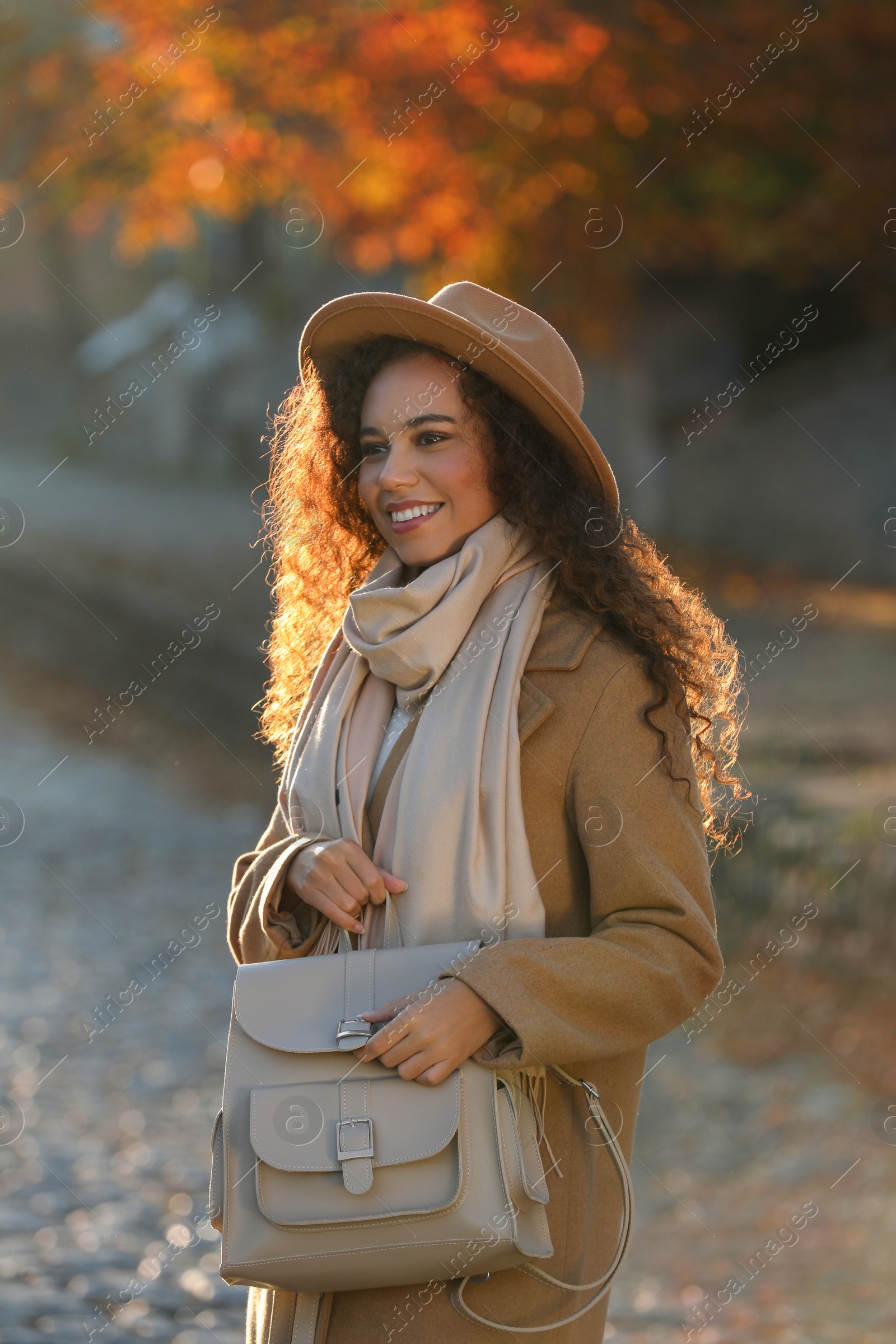 Photo of Portrait of beautiful African-American woman with stylish beige backpack on city street