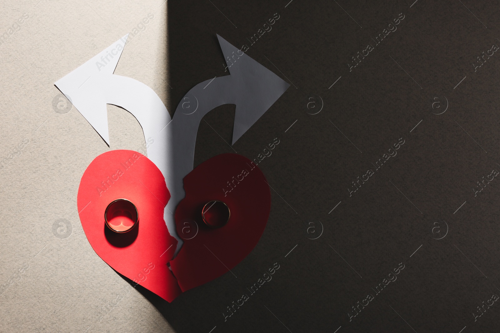 Photo of Divorce concept. Paper heart, arrows and rings on light grey background, flat lay with space for text