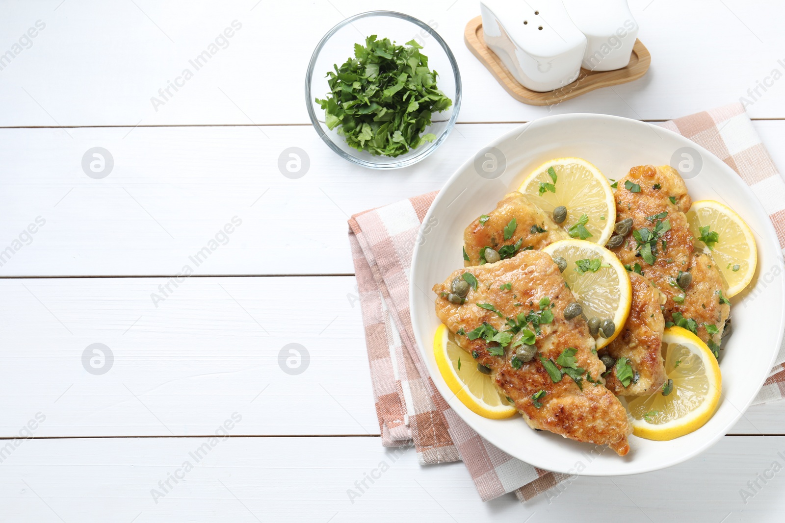 Photo of Delicious chicken piccata on white wooden table, flat lay. Space for text