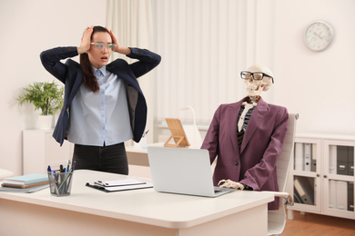 Young woman working with skeleton in office