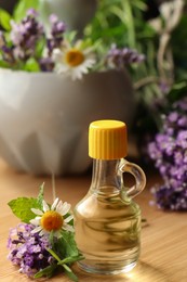 Bottle of natural lavender essential oil near mortar with flowers on wooden table