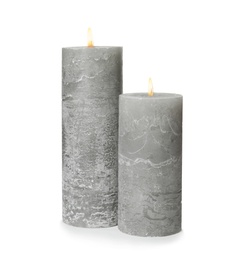 Two alight wax candles on white background