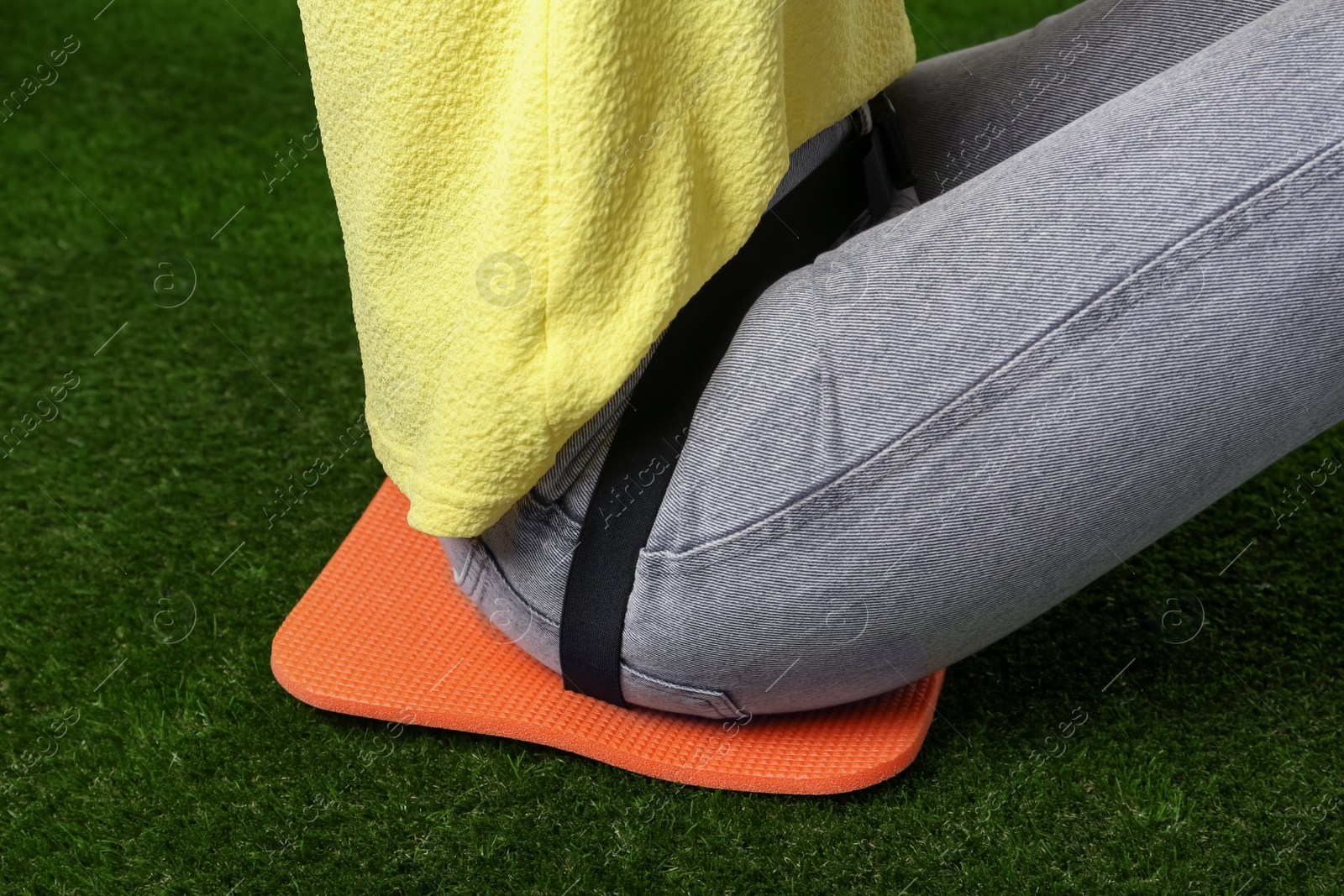 Photo of Woman sitting on foam tourist mat outdoors, closeup