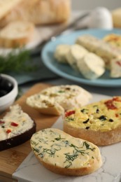 Photo of Different types of tasty butter and bread on table, closeup