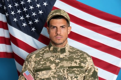 Photo of Soldier in uniform and United states of America flag on light blue background