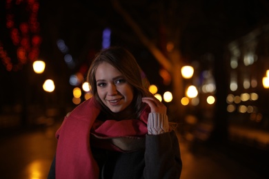 Beautiful young woman spending time in city at night