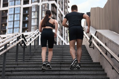 Photo of Healthy lifestyle. Couple running up steps outdoors, low angle view
