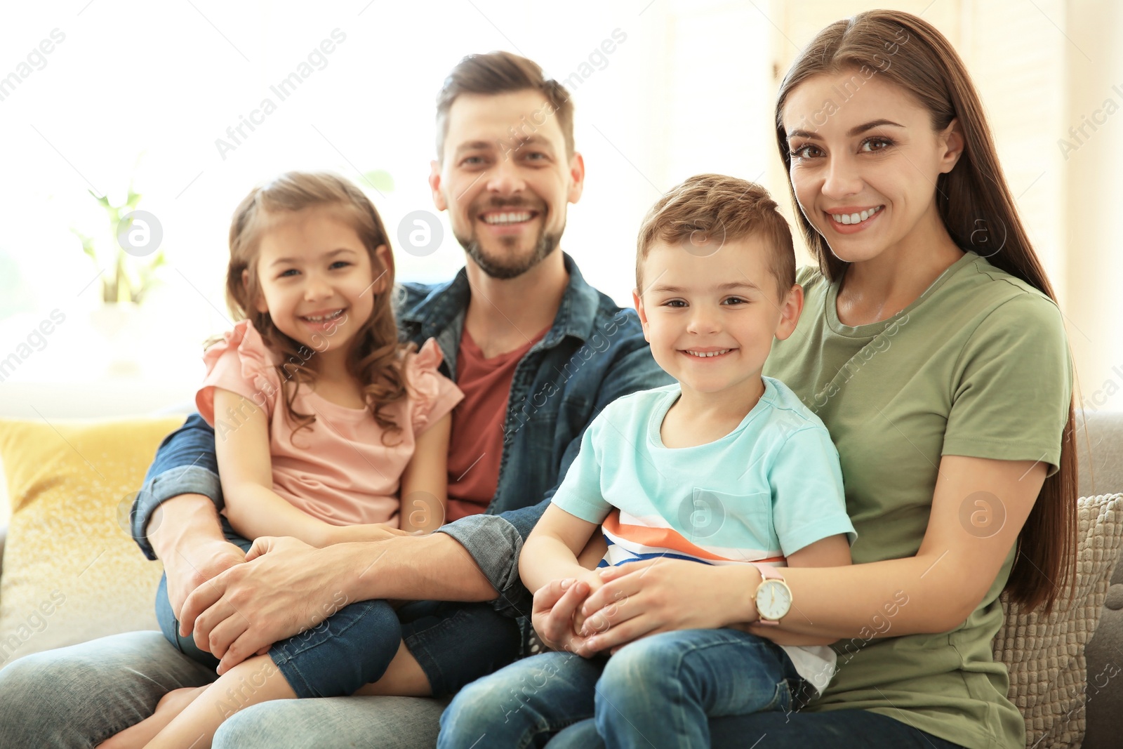 Photo of Young happy family with children at home