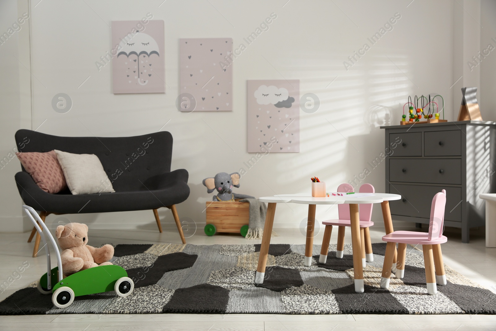 Photo of Cute children's room interior with sofa and little table