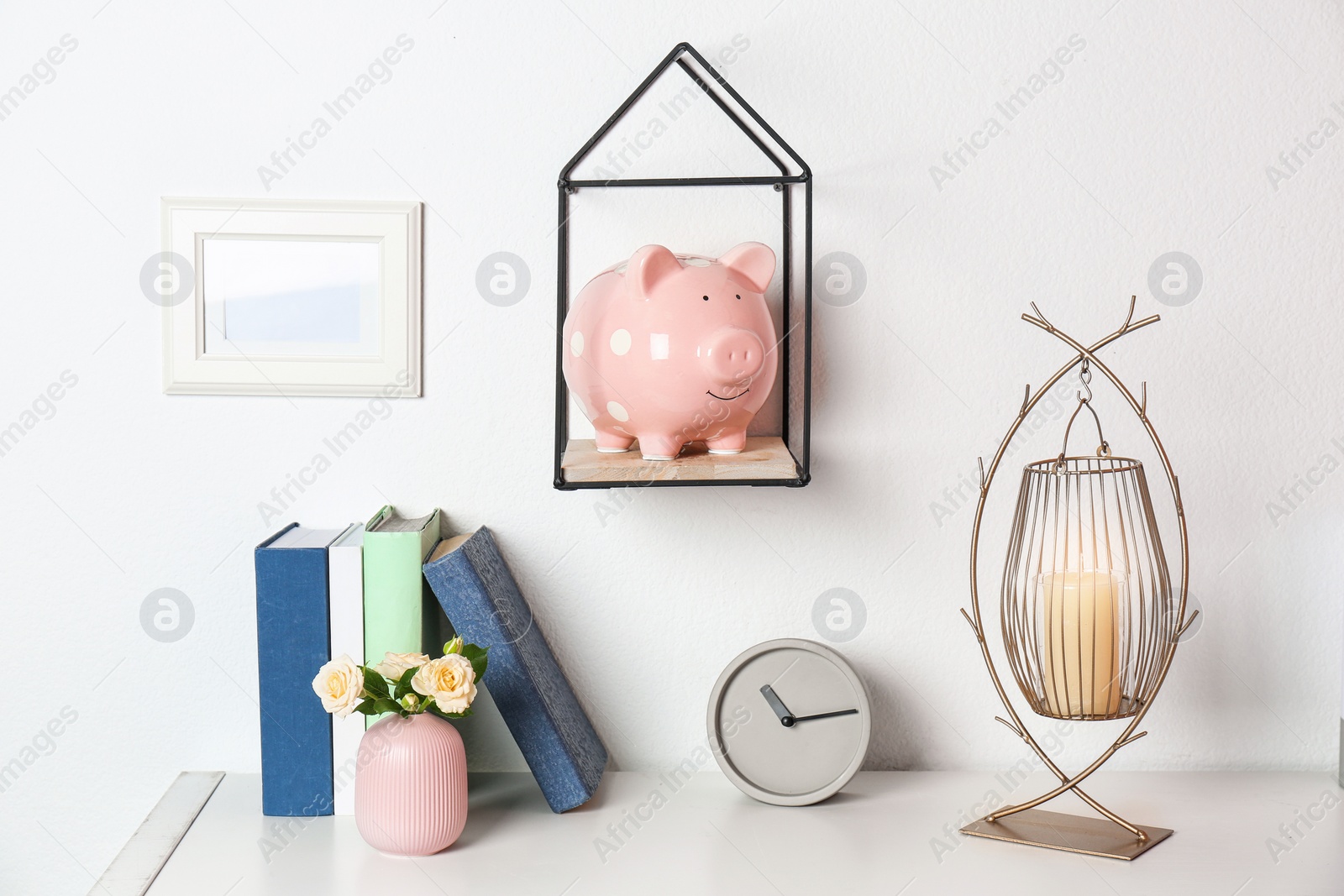 Photo of Cute piggy bank on shelf indoors. Stylish interior element