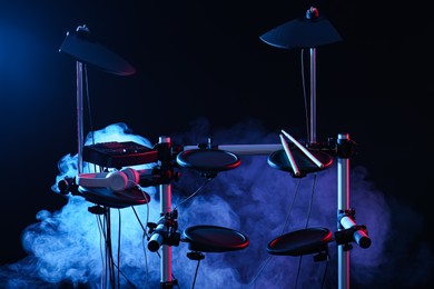 Modern electronic drum kit and smoke on dark background, color toned. Musical instrument