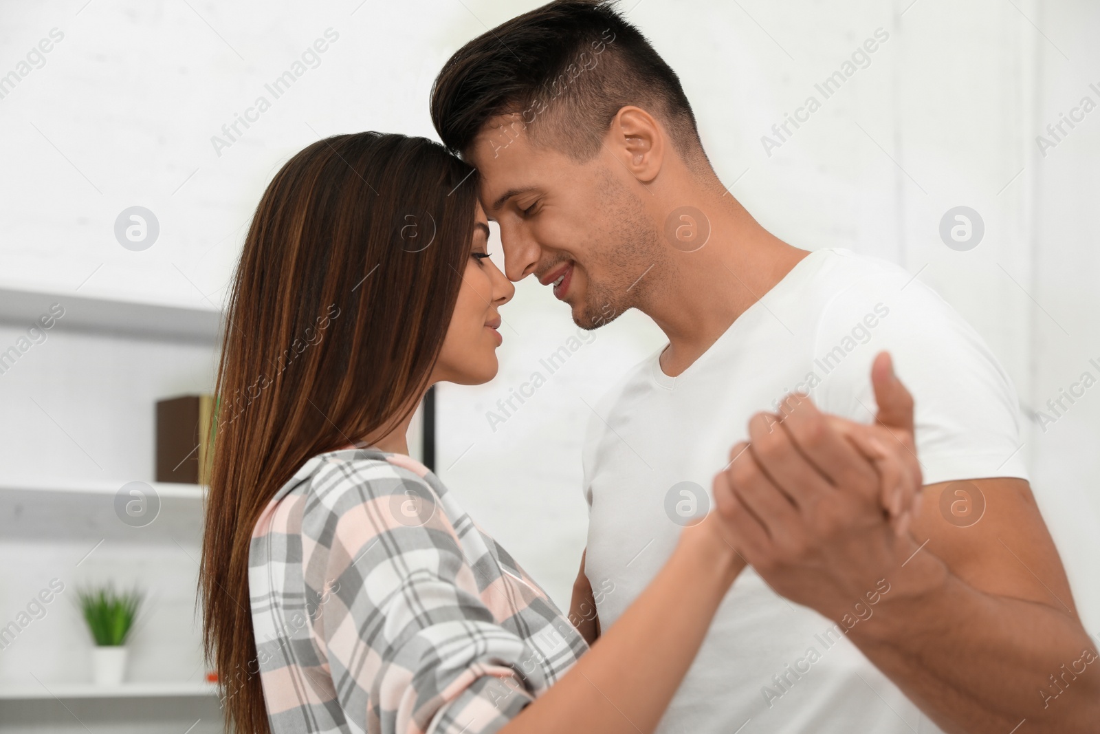 Photo of Happy young couple dancing together at home