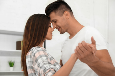 Happy young couple dancing together at home