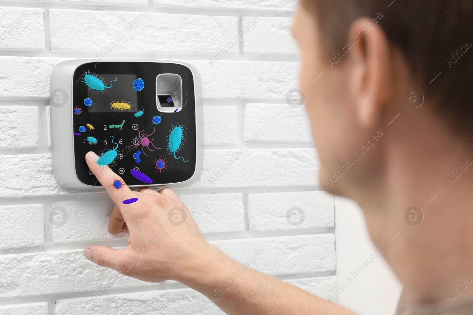 Image of Man using security alarm system full of microbes indoors, closeup