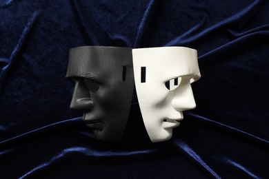 Photo of Theater arts. Two masks on blue fabric, top view